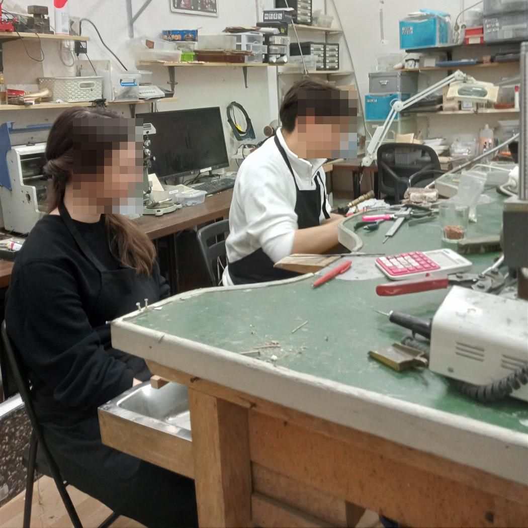 Pareja fabricando sus alianzas en el taller de Crisan Joiers